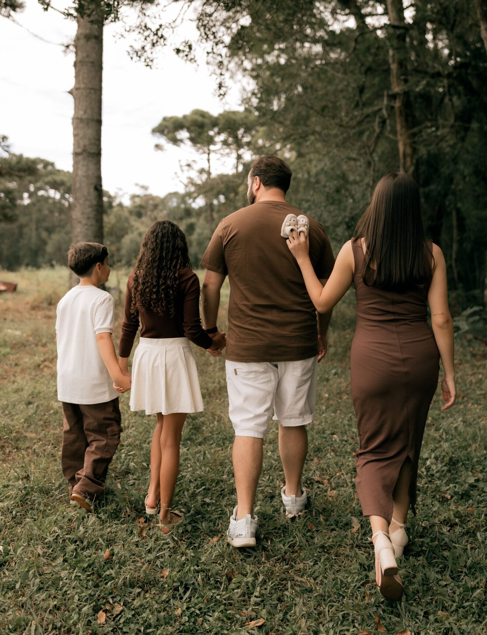 A family walking together in a serene forest, symbolizing unity and nature enjoyment.